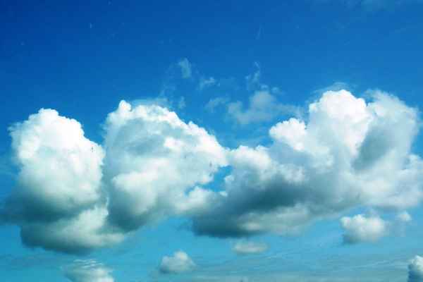 Weiße Wölkchen vor strahlend blauem Himmel