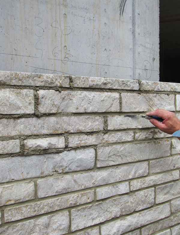 Bauen - Natursteinvorsatzwand wird verfugt