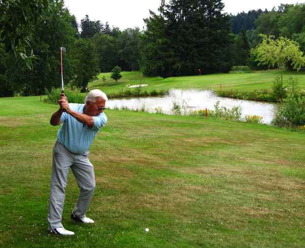 Seniorengolfer vor Wasser und Grün