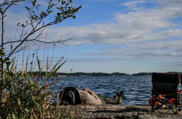 Mann liegt am Ufer