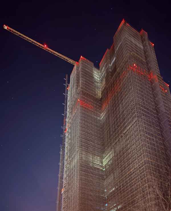 Steglitzer Kreisel Berlin: Hochhausbau bei Nacht mit Ger&uuml;stbeleuchtung