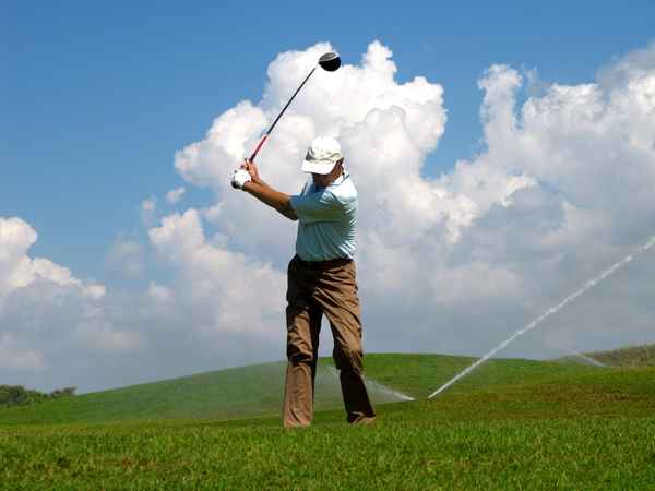 Seniorengolfer vor Abschlag gegen Himmel