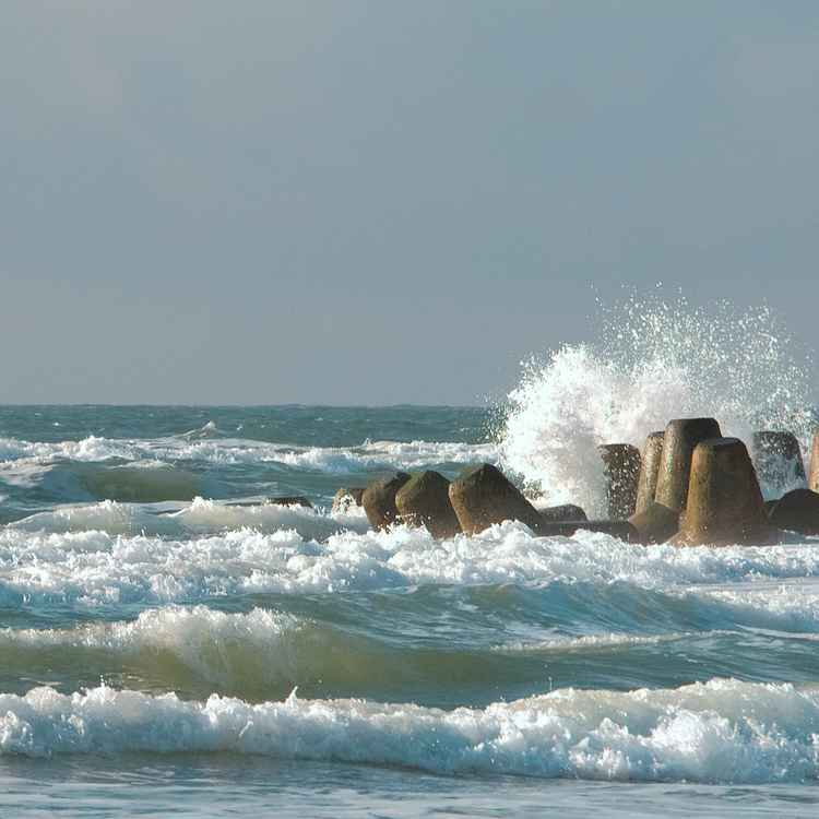 Welle klatscht an Tetrapoden