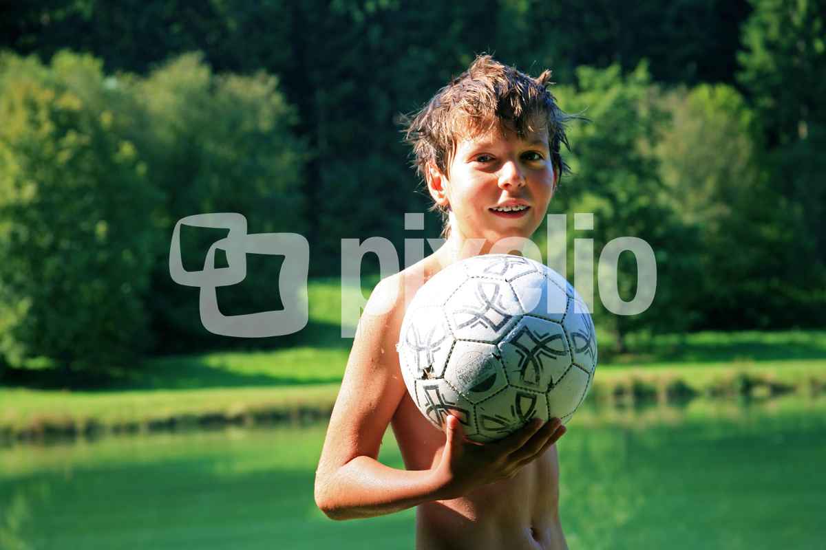 Junge am Badesee mit Ball