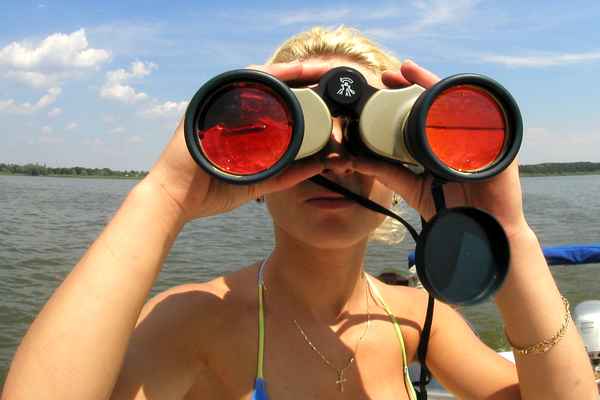 Frau schaut durch ein Fernglas