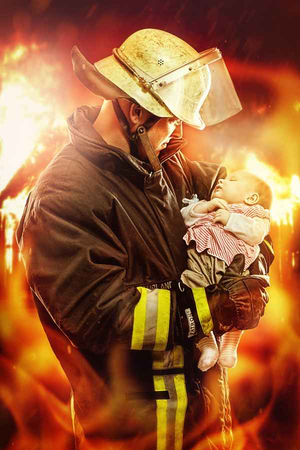 Feuerwehrmann mit Kind im Arm