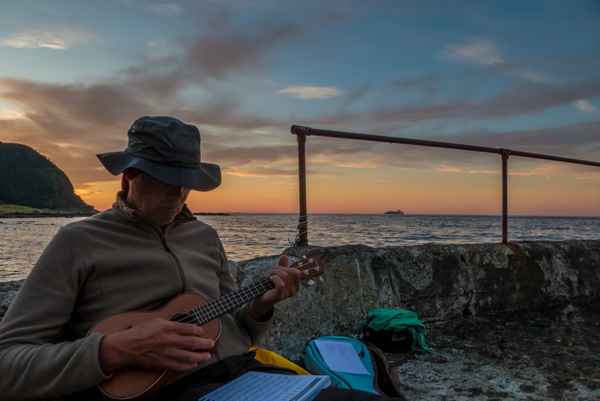 mit der Ukulele im Sonnenuntergang im Hafen