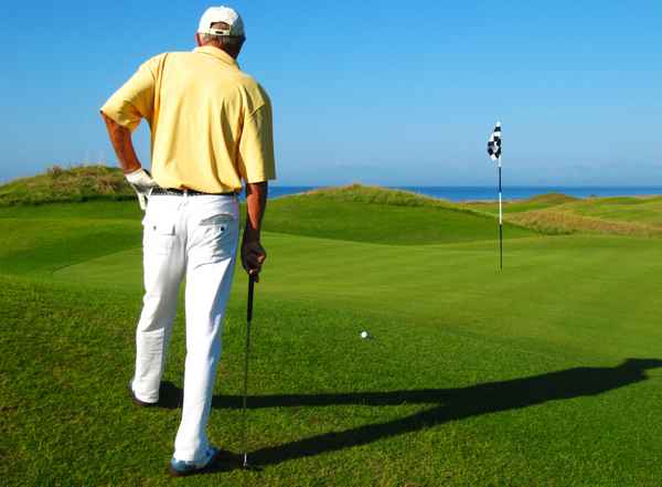 Seniorengolfer am Grün, morgens, am Meer