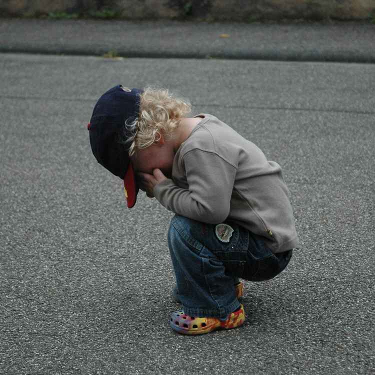 Kind auf Strasse - traurig