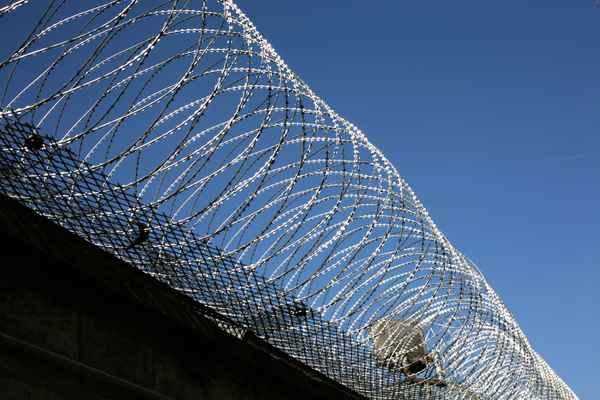 Stacheldraht auf Gefängnismauer