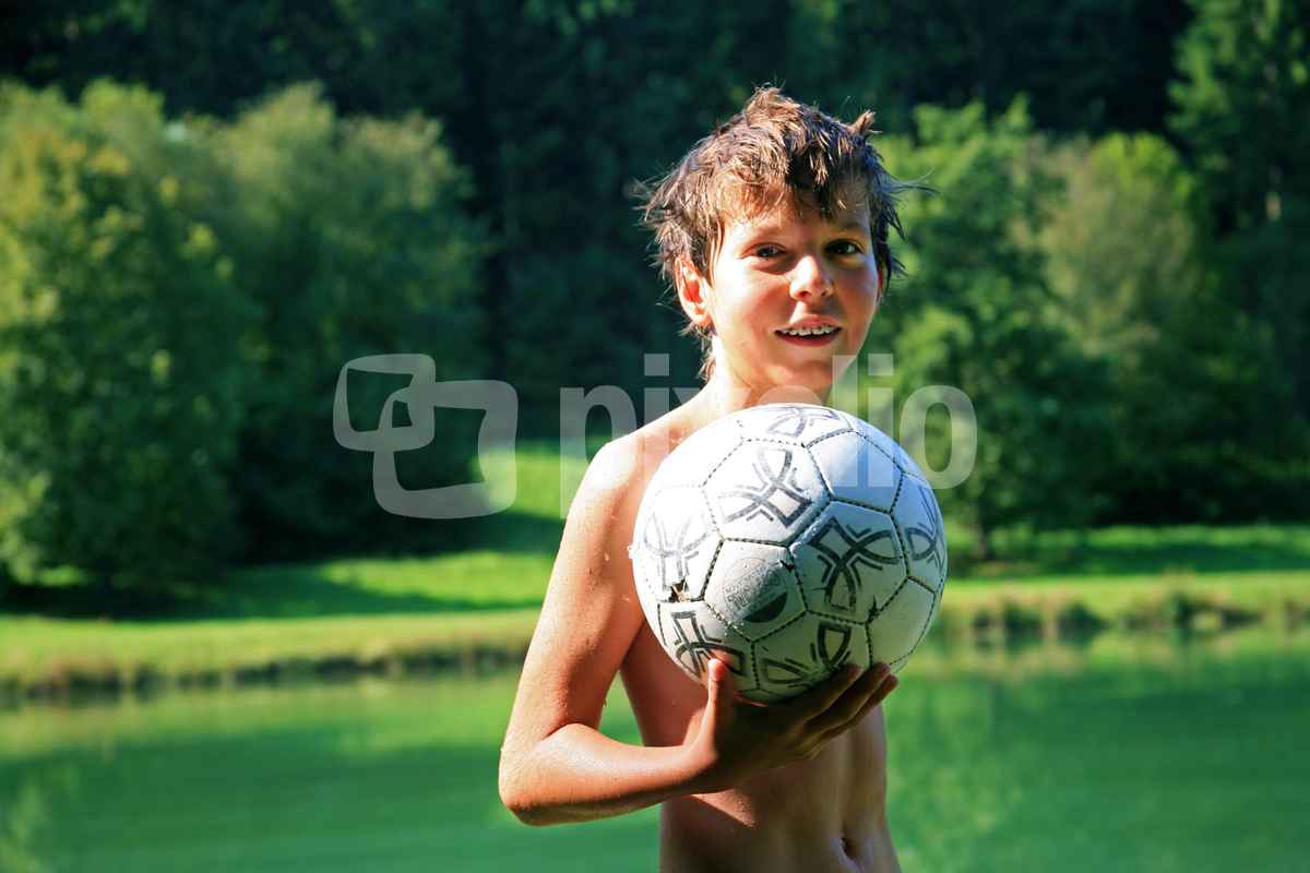 Junge am Badesee mit Ball