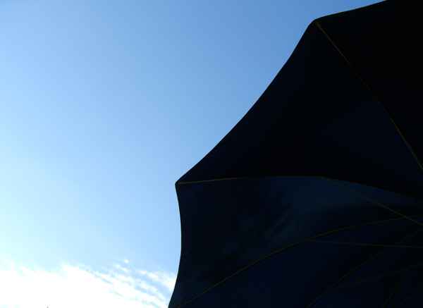 Blauer Sonnenschirm und blauer Himmel