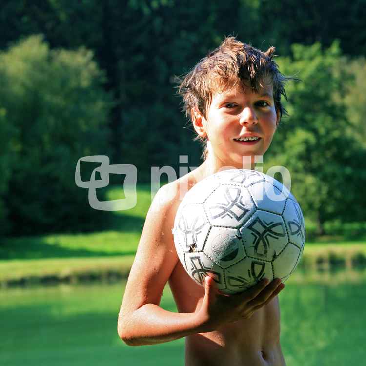 Junge am Badesee mit Ball
