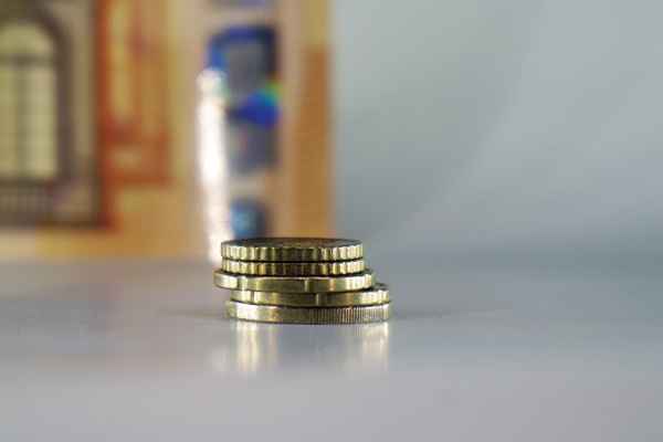 Euromünzen Stapel vor einem 50-Euro-Schein