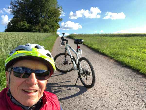 Senior mit MTB am Berganstieg