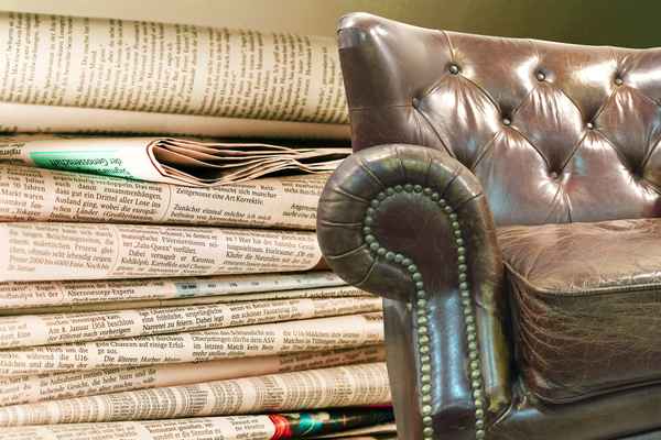 Zeitungsleser und Ledersessel