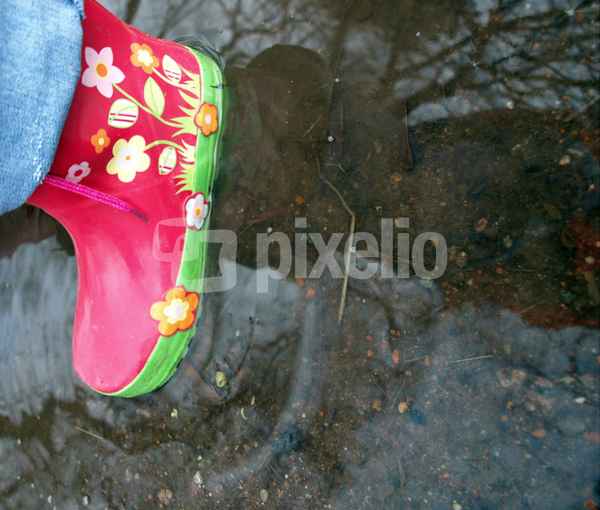 Kinderfuß im Gummistiefel