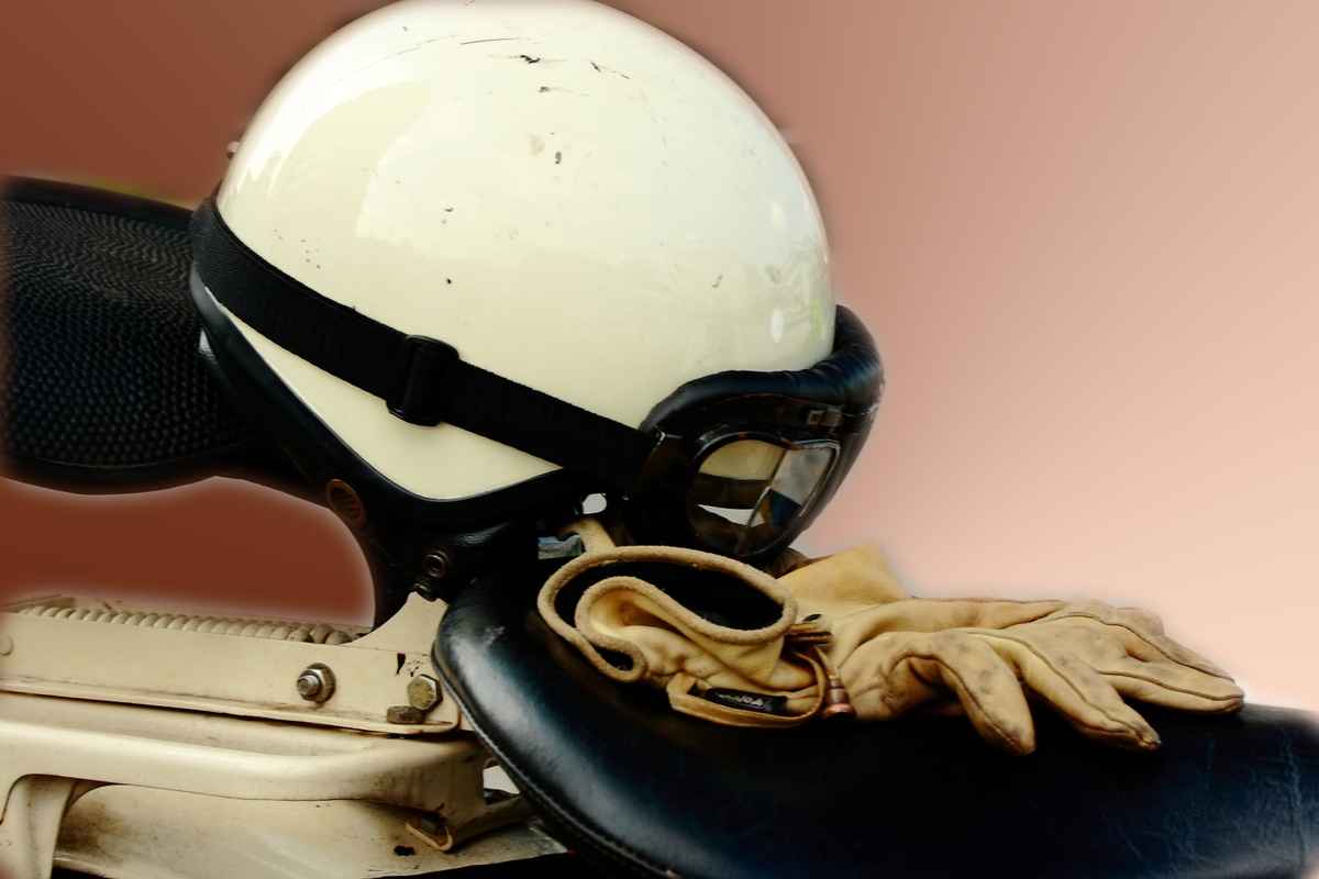alter Motorradhelm mit Brille und Handschuhen