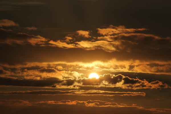 Sonne versinkt in goldenen Wolken
