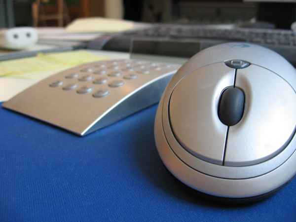 Computermaus und Taschenrechner auf dem Schreibtisch