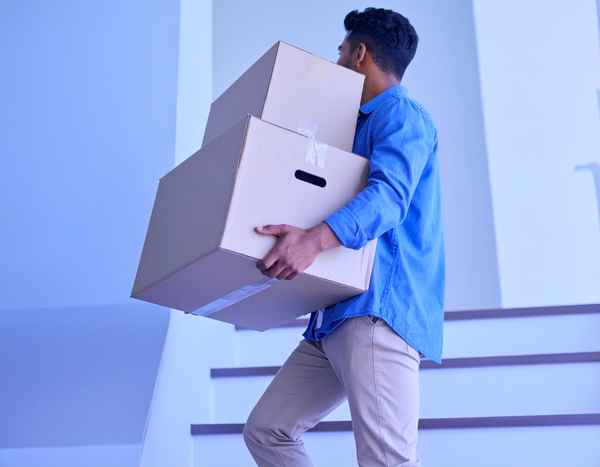 Junger Mann tr&auml;gt Umzugskartons
