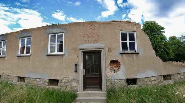 Fassade eines teilweise abgerissenes Hauses mit Eingangstür