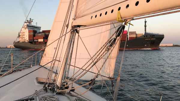 Kreuzen vor einem Containerschiff auf der Elbe