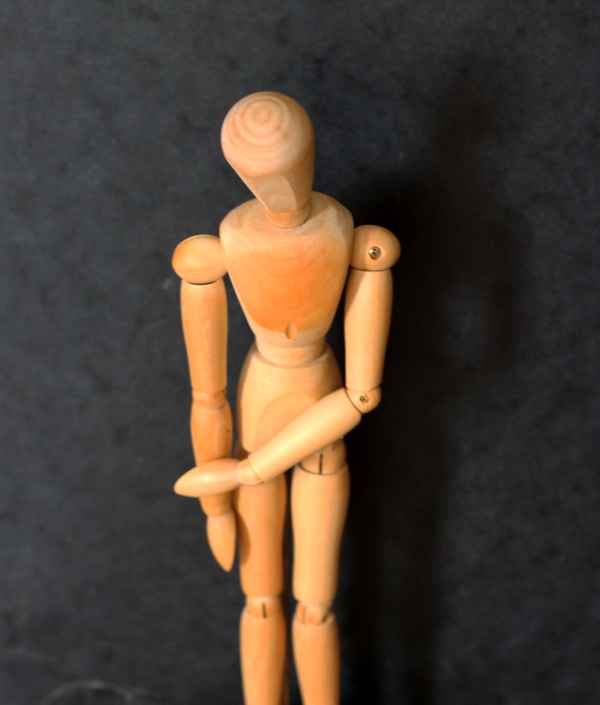 Holzfigur in trauriger Haltung