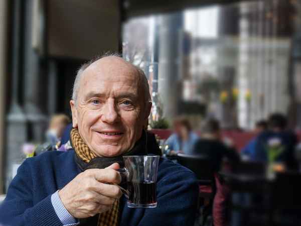 Senior mit Glühwein im Cafe
