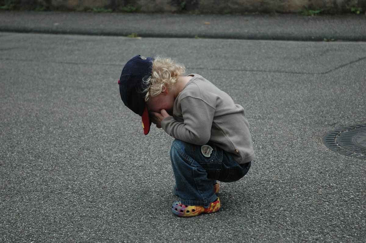 Kind auf Strasse - traurig