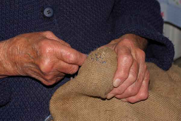 Großmutter flickt Säcke