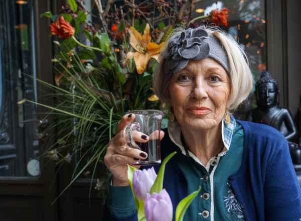 Seniorin mit Glühwein im Cafe